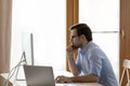 Pensive young businessman in eyewear working on computer. Royalty Free Stock Photo