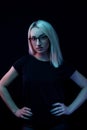 Pensive young Caucasian beautiful blonde woman with glasses . close-up portrait in neon light Royalty Free Stock Photo