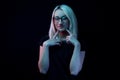 Pensive young Caucasian beautiful blonde woman with glasses . close-up portrait in neon light Royalty Free Stock Photo