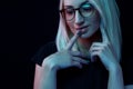 Pensive young Caucasian beautiful blonde woman with glasses . close-up portrait in neon light Royalty Free Stock Photo