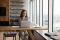 Pensive female employee work online on laptop Royalty Free Stock Photo
