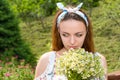 Pensive young girl smelling flowers Royalty Free Stock Photo