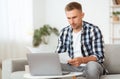 Pensive young guy sitting at desk, looking at documents Royalty Free Stock Photo