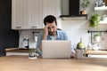 Pensive young male freelancer using laptop thinking on difficult problem