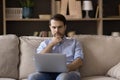 Pensive young man working on computer at home. Royalty Free Stock Photo
