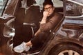 A pensive young man sitting in the back seat of the luxury car. Royalty Free Stock Photo