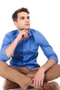 Pensive young man sitting with his legs crossed Royalty Free Stock Photo