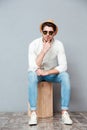 Pensive young man in sunglasses sitting and thinking Royalty Free Stock Photo