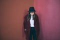 Pensive young teen girl stands against the red wall. Sad doubts. Melancholic mood to be alone with yourself