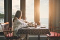 Pensive young woman dinner alone in the room. backview to the sea Royalty Free Stock Photo