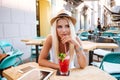 Pensive young woman drinking cocktail and thinking in outdoor cafe Royalty Free Stock Photo