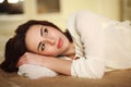 Pensive young woman lying on the bed at home Royalty Free Stock Photo