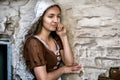 Pensive young woman in a rustic dress standing near old brick wall in old house feel lonely. Cinderella style Royalty Free Stock Photo