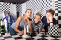 Pensive woman solving puzzle with teen sons in quest room