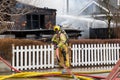 Penticton, BC, Canada - March 7, 2022: Firefighter getting a water hosse to put out a blaze at the historic Warren House that was