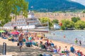 People sun bathe and swim on Okanagan Beach at Okanagan Lake