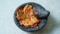 Penyet tempeh with chili sauce in a stone mortar