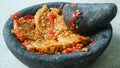 Penyet tempeh with chili sauce in a stone mortar