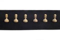 Peon chess figurines set out in a line, in black and white background Royalty Free Stock Photo