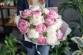 Pink and white peonies in womans hands. Beautiful peony flower for catalog or online store. Floral shop concept