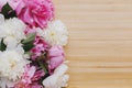 Peony bouquet on wooden background top view with space for text. Pink and white peonies flowers Royalty Free Stock Photo