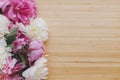 Peony bouquet on wooden background top view with space for text. Pink and white peonies flowers Royalty Free Stock Photo