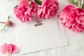 Peony flowers and blank white paper post card on pure linen table cloth background. Invitation floral card in vintage style Royalty Free Stock Photo