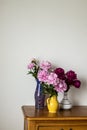 Peony flowers in jugs standing on a table