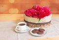 Peony flowers in wicker basket, cup of coffee and cookies on wooden table Royalty Free Stock Photo