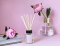 Peony home fragrance with aroma stick on the pink table.