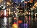 Peopl walk with umbrella,City night light  street reflection  car traffic buildings blurred light red yellow bokeh vew from window Royalty Free Stock Photo