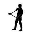 Silhouette of a man in worker costume in doing his task with big cutting tool. Royalty Free Stock Photo