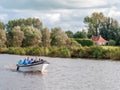 People aboard sloop boat on canal near Grou in Friesland, Netherlands