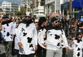 People in ace of clubs card costumes walking along a street