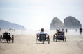 People actively relax riding tricycles enjoying the fresh sea air on the Pacific Ocean