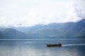 A small Boat is sailing in calm Toba Lake, Samosir Island, North Sumatra, Indonesia.