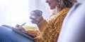 People activity at home - beautiful happy lady relaxed on the sofa taking notes and writing on notes - drink healthy tea or coffee