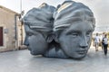 People admire Mucem sculpture, three heads sculpture at Fort St