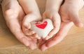 People, age, family, love and health care concept - close up of senior woman and little boy hands holding red heart over wooden Royalty Free Stock Photo