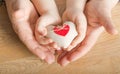 People, age, family, love and health care concept - close up of senior woman and little boy hands holding red heart over wooden Royalty Free Stock Photo