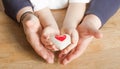 People, age, family, love and health care concept - close up of senior woman and little boy hands holding red heart over wooden Royalty Free Stock Photo