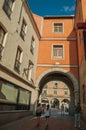 People on alley and colorful building with passageway at Avila