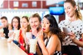 People in American diner or restaurant with milk shakes Royalty Free Stock Photo