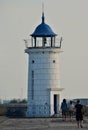 People approaching the old lighthouse on the seafront of the Mangalia city in Romania Royalty Free Stock Photo