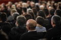 People in the audience watching a classical concert inside a hall