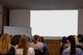 People in auditory during presentation or seminar. Teenagers or young men and women at university lecture or seminar. Back side