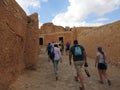 People, back view, go to the mountain oasis of Chebika with palm trees in the sandy Sahara desert, blue blue sky, Tunisia, Africa Royalty Free Stock Photo