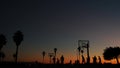 People on basketball court playing basket ball game. Sunset on beach, California Royalty Free Stock Photo