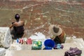 People bathing and washing on the riverbank of Irrawaddy River, next to chinthe statues, Burma