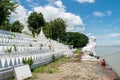 People bathing and washing on the riverbank of Irrawaddy River, next to chinthe statues, Burma